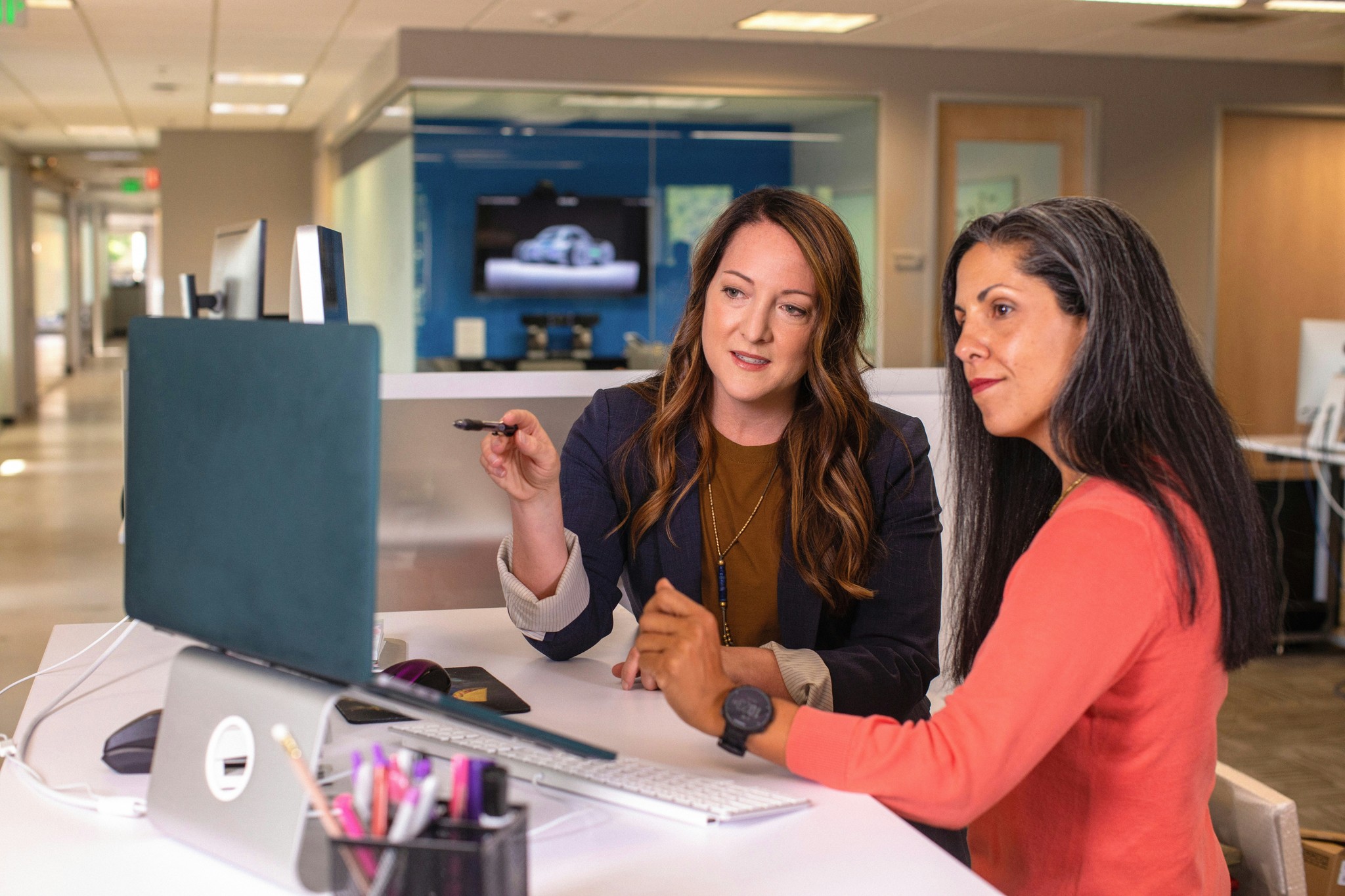 Two businesswomen discussing work at a computer